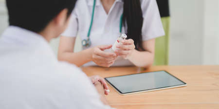 Close-up view of young female doctor explaining medical description to her patient の写真素材