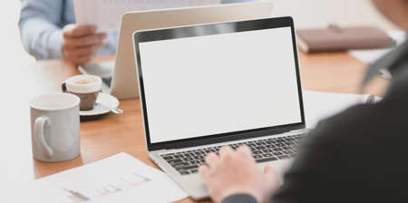 Cropped shot of group of professional businesspeople discussing their current project together while using laptop の写真素材
