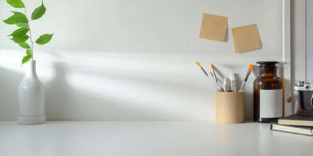 Minimal workspace with copy space and ceramic vase decorations and office supplies の写真素材