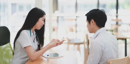 Close-up view of young professional female doctor explaining medical description to her patientの写真素材