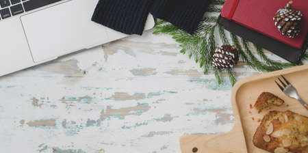 Top view of Christmas decorated workplace  with laptop computer, coffee cup and present on vintage wooden desk background