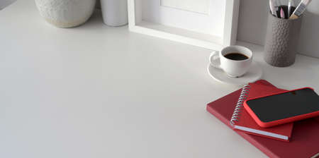 Minimal workspace with mock up frame and copy space with ceramic vase decorations and smartphoneの写真素材