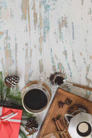 Top view of Christmas decorated workplace coffee cup and present on vintage wooden desk backgroundの写真素材