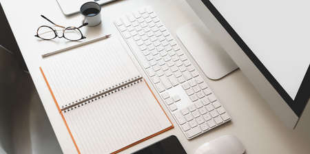 Cropped shot of modern workplace with open blank notebook, keyboard computer and desktop computer...