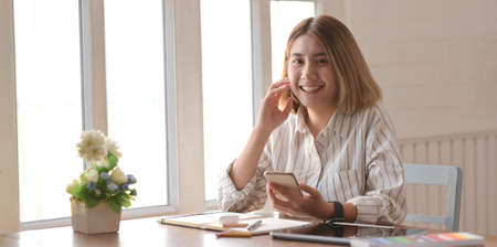 Professional young female designer working on her project with digital tablet in comfortable...