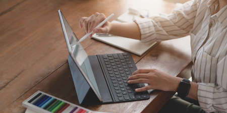 Cropped shot of young female designer editing her project with tablet in comfortable office roomの写真素材