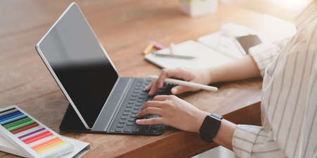 Cropped shot of young professional designer working on her project with blank screen tabletの写真素材