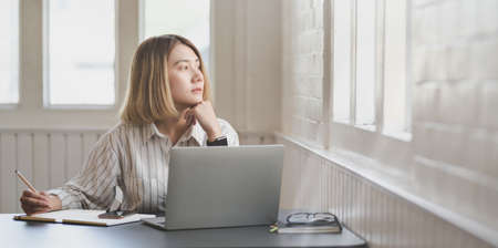 Young professional businesswoman working on her project and writing on notebookの写真素材