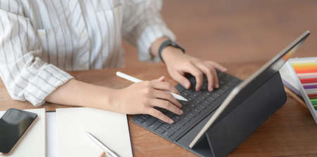Close-up view of young professional designer working on her project with blank screen tabletの写真素材