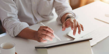 Cropped shot of professional businessman working on his project with digital tablet in modern office roomの写真素材