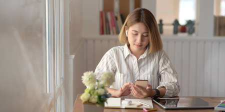 Professional young female designer working on her project with digital tablet in comfortable workspaceの写真素材