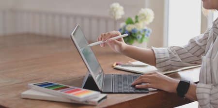 Cropped shot of young female designer editing her project with tablet in comfortable office roomの写真素材
