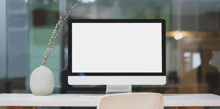 Modern workspace with blank screen desktop computer and decorations on white table and blurred backgroundの写真素材