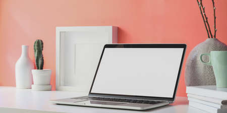 Minimal workplace with open blank screen laptop with copy space and office suppliesの写真素材