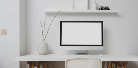 Modern workspace with blank screen desktop computer and decorations on white table and white wall backgroundの写真素材