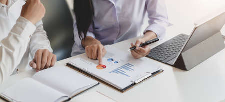Cropped shot of two professional business partner discussing their project together while using graphs and charts の写真素材