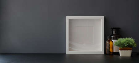 Mock up frame with office supplies and decorations in dark trendy workspace の写真素材
