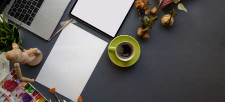 Overhead shot of artist workspace with sketch paper and painting tools on dark grey background の写真素材