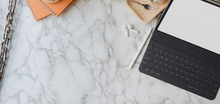 Overhead shot of stylish workspace with digital tablet and office supplies on marble desk backgroundの写真素材