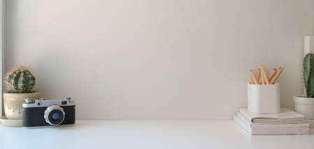 Minimal workplace with copy space and office supplies on white wooden table and white wall backgroundの写真素材