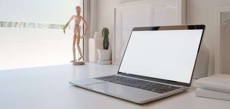 Open blank screen laptop computer in minimal workspace with cactus pots and decorations