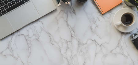 Overhead shot of modern photographer workspace with laptop computer and office accessories on marble...