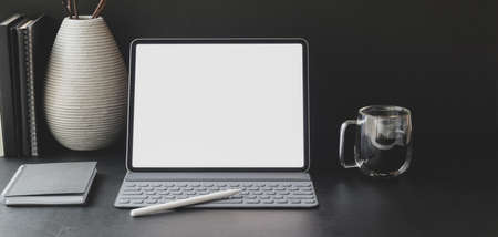 Close-up view of modern workplace with blank screen tablet with office supplies with ceramic decorationsの写真素材