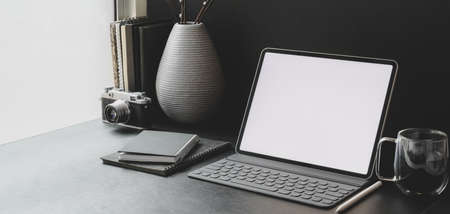 Cropped shot of modern workplace with blank screen tablet with office supplies with ceramic decorationsの写真素材