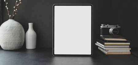 Cropped shot of modern workplace with blank screen tablet with office supplies with ceramic decorationsの写真素材