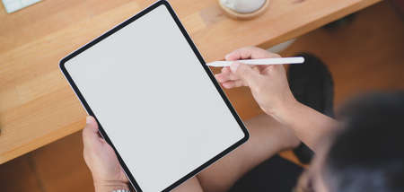 Close-up view of man working on his project with blank screen tablet in his comfortable roomの写真素材
