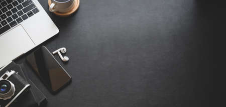 Top view of dark modern workspace with laptop computer, smartphone and office suppliesの写真素材