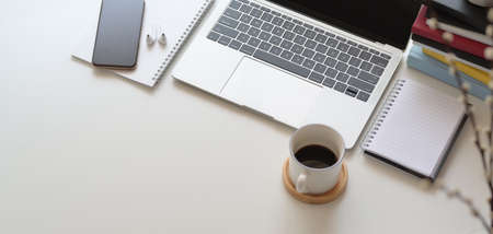 Top view of comfortable workspace with laptop computer and office supplies on white wooden tableの写真素材
