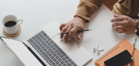 Cropped shot of man working on his project while typing on laptop computer in his comfortable roomの写真素材