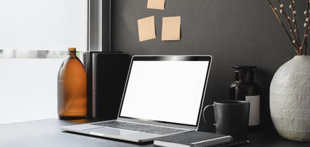 Modern office room with blank screen laptop computer and office supplies with decorationsの写真素材