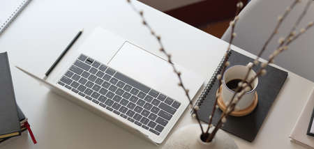 Top view of comfortable workspace with laptop computer and office supplies on white wooden tableの写真素材