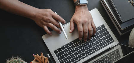 Top view of businessman typing on laptop computer while working on his project in modern office roomの写真素材