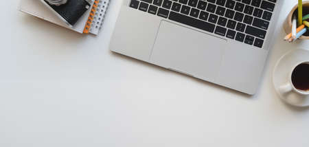 Top view of designer workplace with laptop computer and office supplies on white table backgroundの写真素材