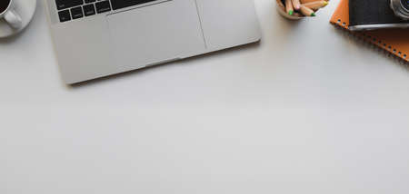 Top view of modern stylish workplace with laptop computer and office supplies on white table backgroundの写真素材