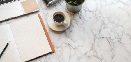 Top view of modern workspace with open notebook and office supplies on marble deskの写真素材