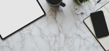 Top view of modern workspace with tablet, smartphone and office supplies on marble table backgroundの写真素材