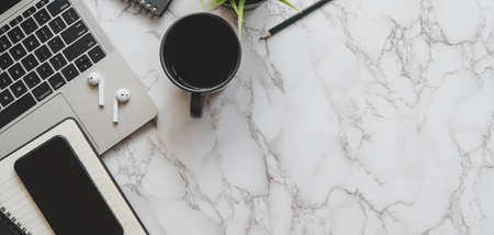 Top view of stylish workspace with laptop computer, smartphone and office supplies on marble desk backgroundの写真素材