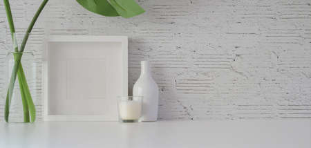 Mock up frame with decorations in minimal office room on white table and white brick wall backgroundの写真素材