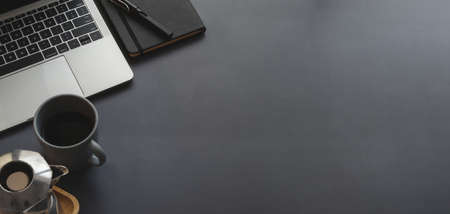 Top view of trendy workplace with laptop computer and copy space with office supplies on black leather backgroundの写真素材