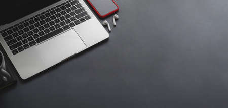 Overhead shot of laptop computer and smartphone with copy space on black table backgroundの写真素材