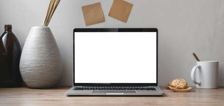 Comfortable workspace with open blank screen laptop computer and office supplies on wooden tableの写真素材