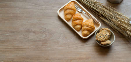 Top view of comfortable workplace with breakfast and copy space on wooden tableの写真素材