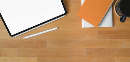 Top view of comfortable workplace with blank screen digital tablet and office supplies on wooden tableの写真素材