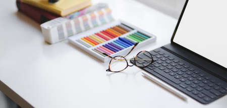 Cropped shot of modern designer office room with blank screen digital tablet and office supplies on white table and copy spaceの写真素材