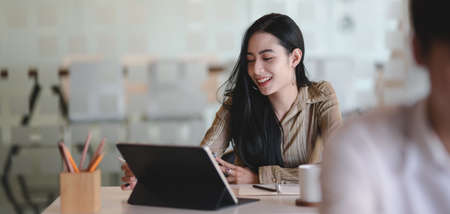 Portrait of young beautiful female designer working on her project with digital tablet