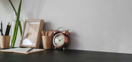 Cropped shot of trendy workplace with office supplies and copy space on black table backgroundの写真素材